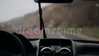 在山区，一辆汽车冒雨在公路上行驶。工作挡风玻璃<strong>雨刮器</strong>